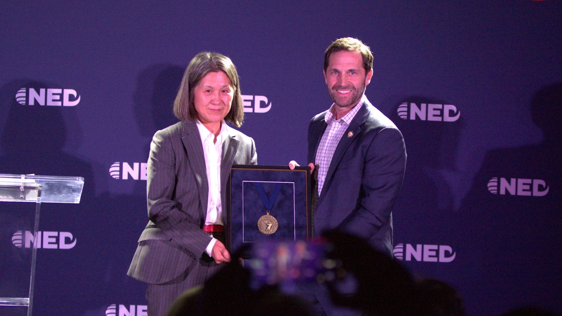 Cao Yaxue accepts the 2025 Democracy Service Medal on behalf of Pastor Wang Yi. (Photo: MK Mindful Media)